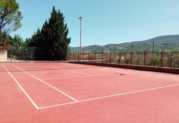 Il campo da tennis in cemento si trova ad un livello inferiore rispetto alla villa - Villa Michelangelo 