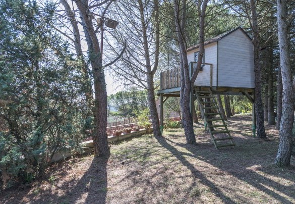 La zona allestita per bambini con giochi da giardino e una casa in legno sugli alberi - Villa Michelangelo  