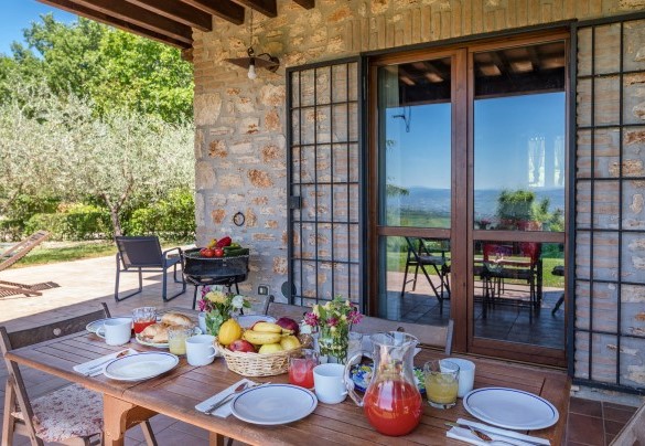 The outdoor dining area under the portico, set up with table, chairs and barbecue - Villa Mila 