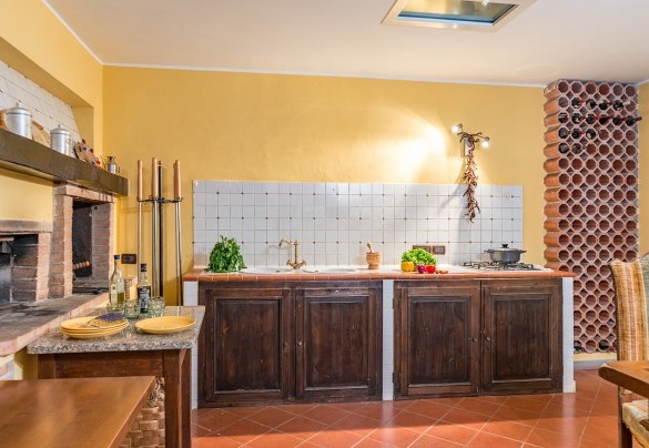 Rustica cucina in muratura con forno a legna e barbecue, con zona pranzo e salotto con tv satellitare nel seminterrato – Villa Monica