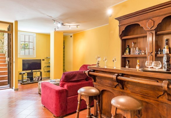 Rustica cucina in muratura con forno a legna e barbecue, con zona pranzo e salotto con tv satellitare nel seminterrato – Villa Monica