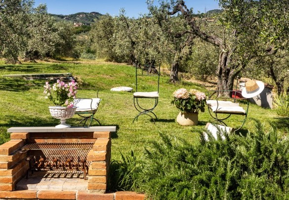 Accanto alla zona pranzo esterna si trova il barbecue fisso ed un piccolo salotto sul prato – Villa Monnalisa