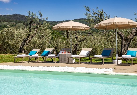 La piscina con area solarium dotata di ombrelloni e lettini – Villa Monnalisa