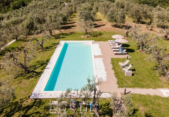 La piscina con area solarium dotata di ombrelloni e lettini – Villa Monnalisa