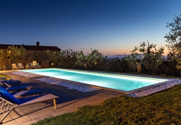  La piscina con area solarium illuminata al tramonto – Villa Monnalisa