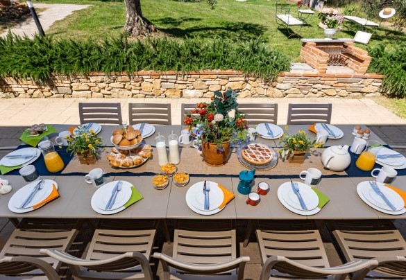 La zona pranzo esterna attualmente ombreggiata da una vela e attrezzata con un barbecue fisso – Villa Monnalisa