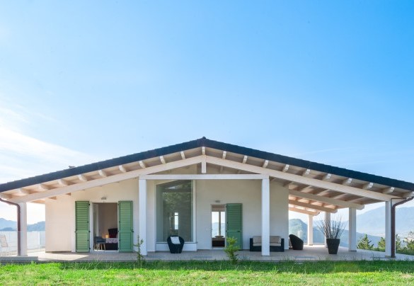 Rear facade of the villa with a sloping roof, large windows, and a well-maintained lawn - Dimora Montefalcone
