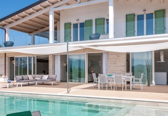 Covered lounge area with a wicker sofa, perfect for outdoor relaxation sheltered from the sun - Dimora Montefalcone