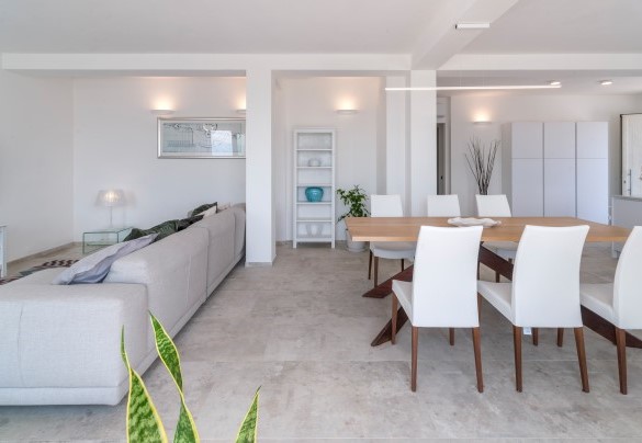 Modern dining area with a wooden table in a bright and airy setting - Dimora Montefalcone