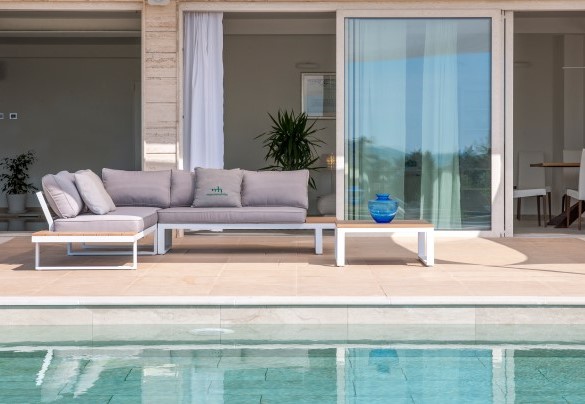 Poolside lounge area with comfortable sofas, ideal for relaxing in the sun or shade - Dimora Montefalcone