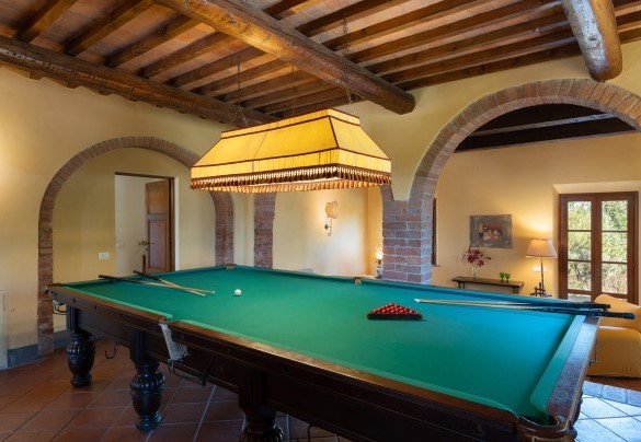 L’ampio salone con camino in pietra con zona pranzo, zone divani con angolo TV e un biliardo – Villa Montefalconi