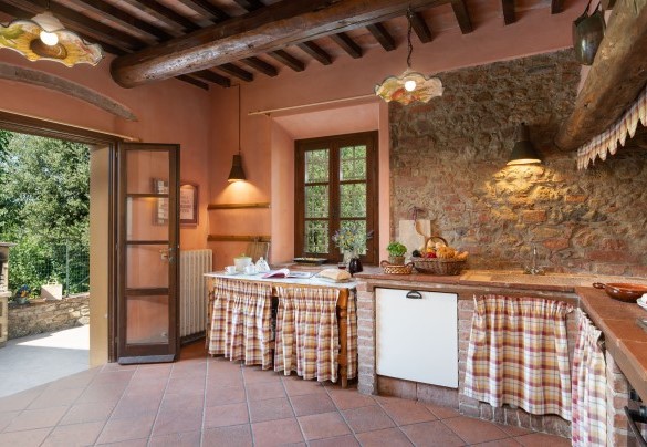 La cucina abitabile in muratura con accesso, mediante porta finestra, al giardino – Villa Montefalconi