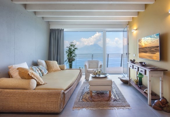 Salotto in stile orientale con accesso al terrazzo, dotato di Smart tv e ampio divano	- Villa Montelago