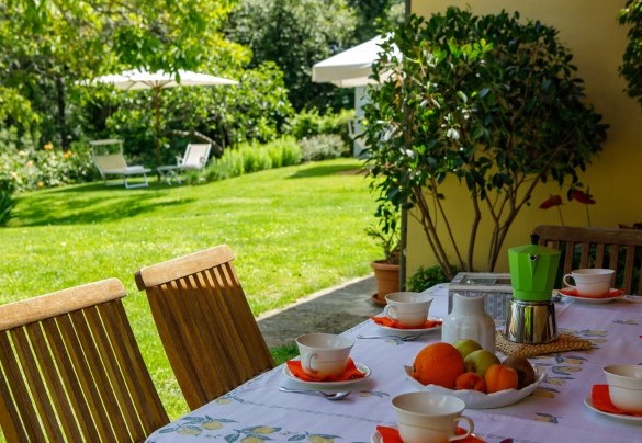 Il punto di forza è costituito dal grande portico con vista sul giardino e sulla piscina, arredato con tavolo e sedie per cene conviviali – Villa Mosca