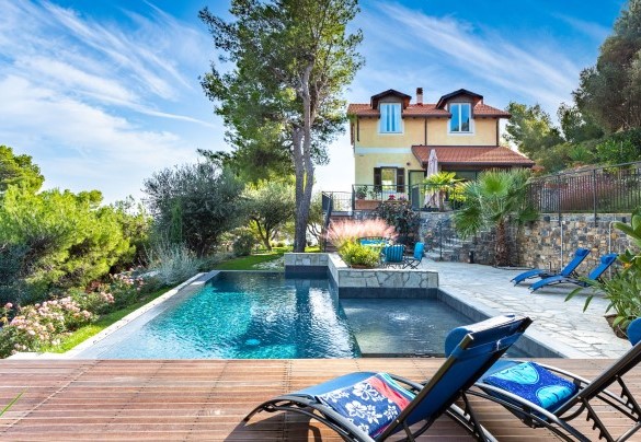 Diverse specie di piante e di colorati fiori adornano il giardino di “Villa nel Blu”, facendo cornice intorno al panoramico solarium della piscina  - Villa Nel Blu