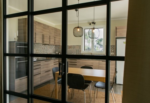 L'ampia cucina del pianterreno con zona pranzo inclusa e l’accesso diretto al giardino - Villa nel Blu