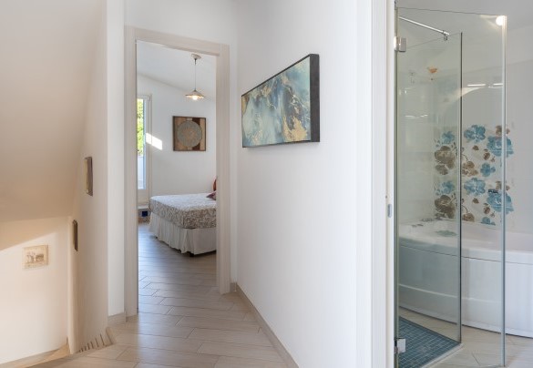 Un corridoio porta al bagno con vasca - Villa Olimpia