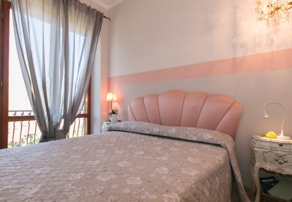 The charming master bedroom on the upper floor overlooks the garden - Villa Ombrosa