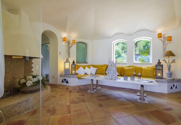 Salotto attrezzato con divano, tavolo regolabile in altezza e camino ornamentale - Villa Padulella 