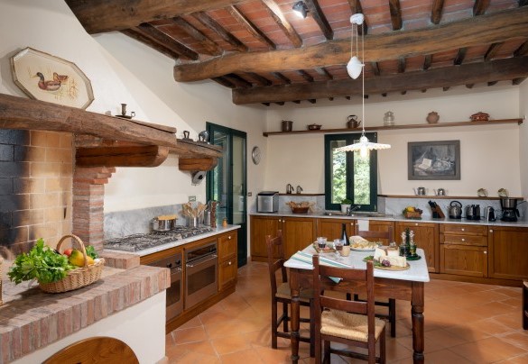 Cucina in muratura ben accessoriata con camino ornamentale- Villa Paesante  
