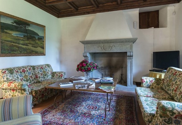 The living room on the ground floor with a fireplace and TV - Villa Palazzaccio