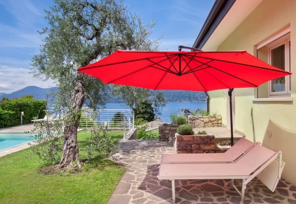 The sunbeds and the large umbrella in the pool area - Villa Palladini