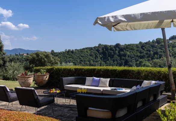 Una delle due aree salotto, arredate con divani e poltrone, poste davanti alle porte finestra del living - Villa Panorama