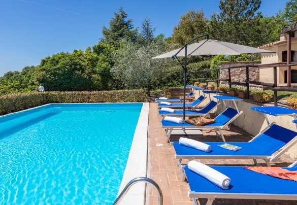 The pool and the sunbath area set up with sunbeds, umbrellas and shower - Villa Paola  