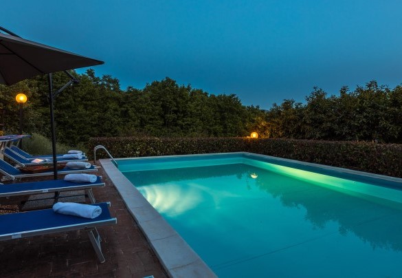 The swimming pool and sunbathing area at sunset - Villa Paola