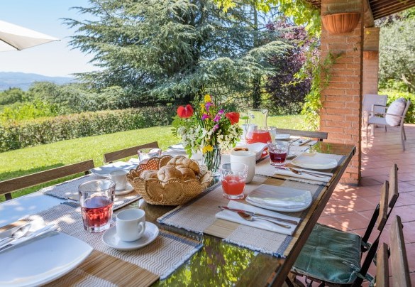 The outdoor dining area under the portico, set up with table and chairs - Villa Paola 