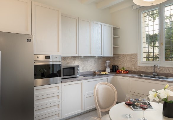Modern equipped kitchen with direct access to the pergola set up with dining area. - Villa Pergola