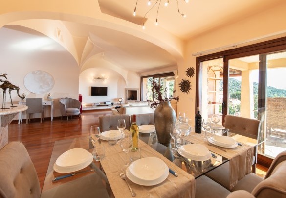 Area living interna comprende una parte adibita a soggiorno, dotata di divano con zona tv, sala da pranzo vista mare – Villa Phoenix
