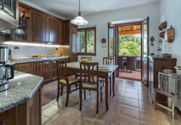 La cucina ben attrezzata collegata al soggiorno con sala da pranzo e al portico - Villa Pianello