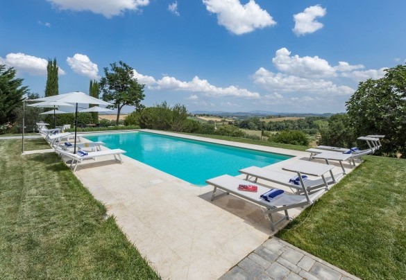 Il solarium in travertino, arredato con lettini, sdraio, ombrelloni, e dotato di una doccia solare - Villa Pianello