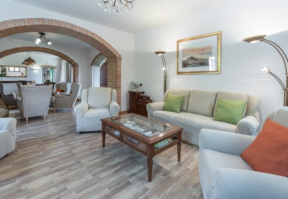 Il grande soggiorno in cui gli ambienti con zona salotto, zona pranzo e zona tv sono collegati da grandi aperture ad arco - Villa Pianello