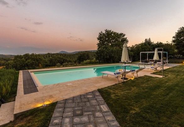 La piscina illuminata nei bagliori del tramonto - Villa Pianello