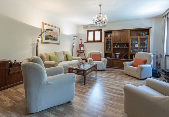 Il grande soggiorno in cui gli ambienti con zona salotto, zona pranzo e zona tv sono collegati da grandi aperture ad arco - Villa Pianello