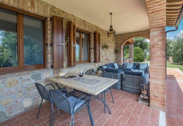 Il portico con l’area living accanto al portone d’ingresso della villa - Villa Pianello
