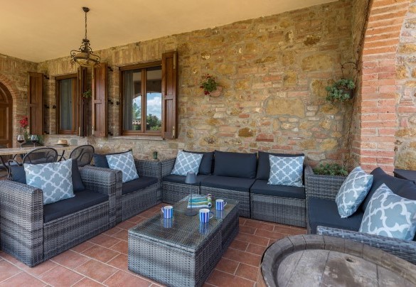 Il portico con l’area living accanto al portone d’ingresso della villa - Villa Pianello