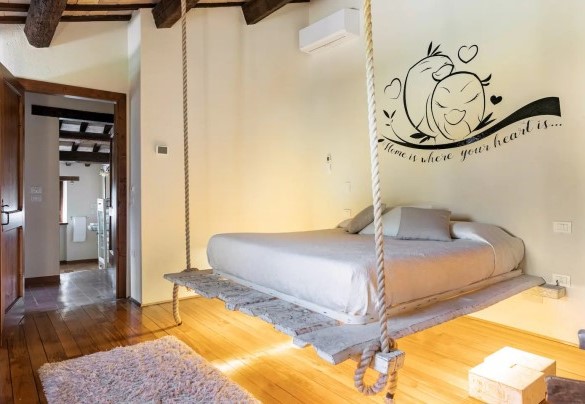 Camera matrimoniale con letto sospeso con corde di juta al piano terra – Villa Poderina