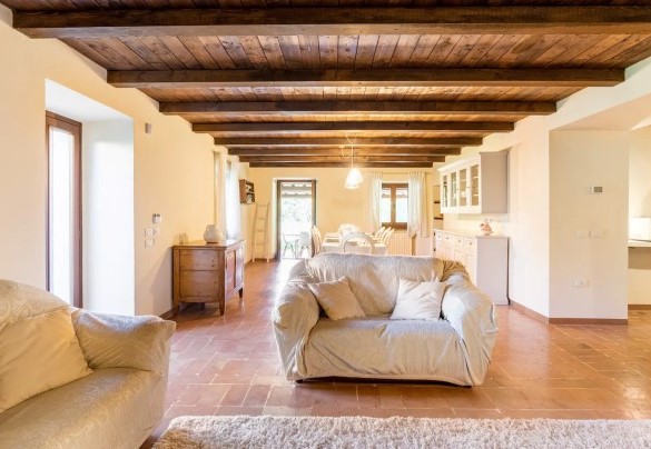 Zona living con camino e sala da pranzo al piano seminterrato – Villa Poderina