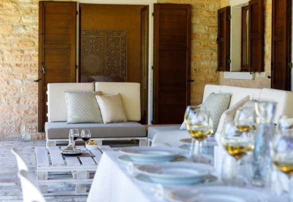 Lo spazioso portico raggiungibile dalla sala pranzo, elegantemente arredato con tavolo, sedie e una suggestiva amaca matrimoniale sospesa – Villa Poderina