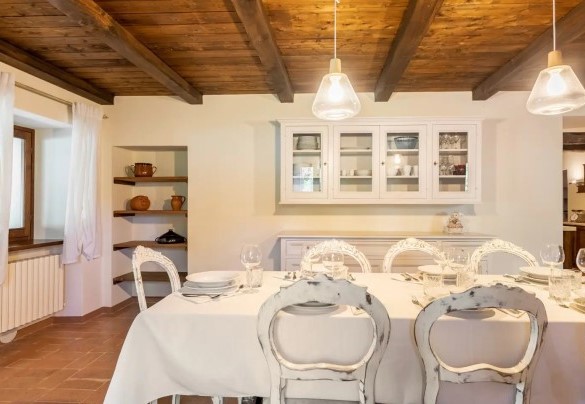 Zona living con camino e sala da pranzo al piano seminterrato – Villa Poderina