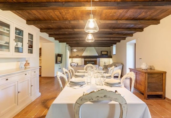 Zona living con camino e sala da pranzo al piano seminterrato – Villa Poderina