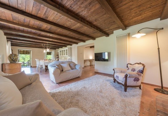 Zona living con camino e sala da pranzo al piano seminterrato – Villa Poderina