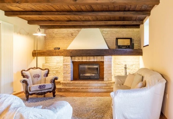 Zona living con camino e sala da pranzo al piano seminterrato – Villa Poderina