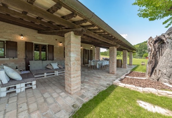 Lo spazioso portico raggiungibile dalla sala pranzo, elegantemente arredato con tavolo, sedie e una suggestiva amaca matrimoniale sospesa – Villa Poderina
