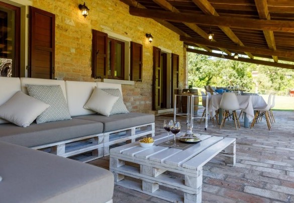 Lo spazioso portico raggiungibile dalla sala pranzo, elegantemente arredato con tavolo, sedie e una suggestiva amaca matrimoniale sospesa – Villa Poderina 