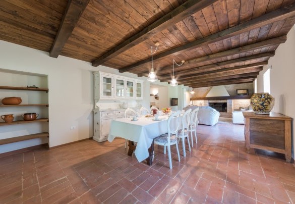 Zona living con camino e sala da pranzo al piano seminterrato – Villa Poderina
