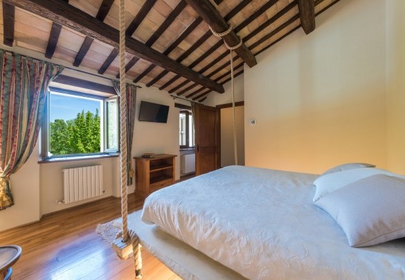 Camera matrimoniale con letto sospeso con corde di juta al piano terra – Villa Poderina